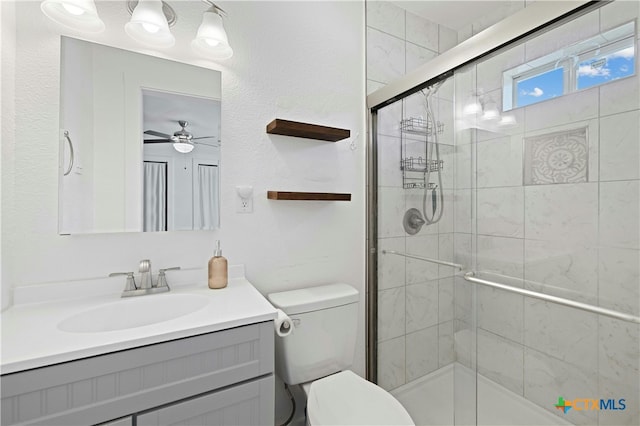 bathroom featuring ceiling fan, vanity, toilet, and an enclosed shower