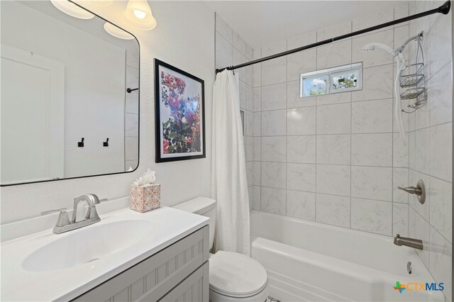 full bathroom with vanity, shower / bath combo with shower curtain, and toilet