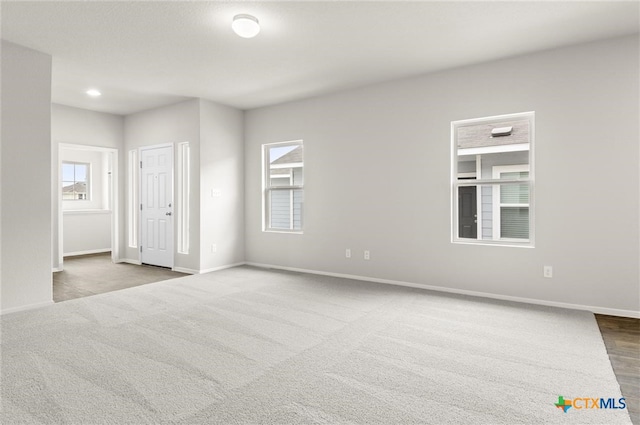 carpeted spare room featuring a healthy amount of sunlight