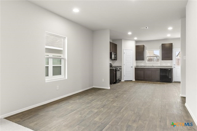 kitchen featuring dark brown cabinetry, sink, black appliances, and light wood-type flooring