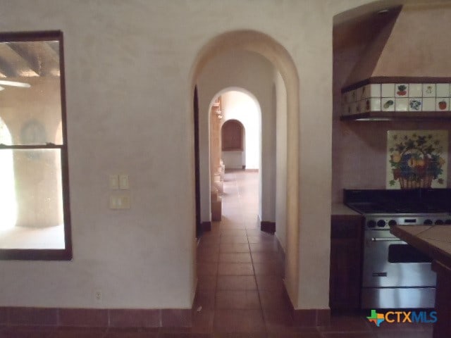 hall with dark tile patterned flooring