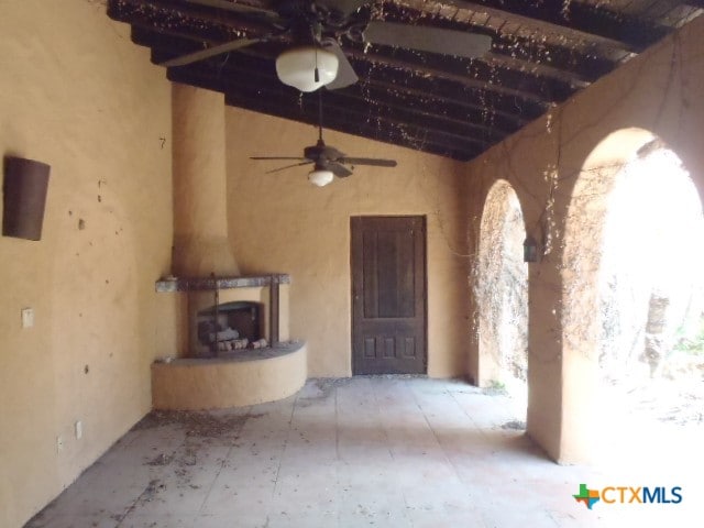 unfurnished living room featuring a fireplace, ceiling fan, and lofted ceiling