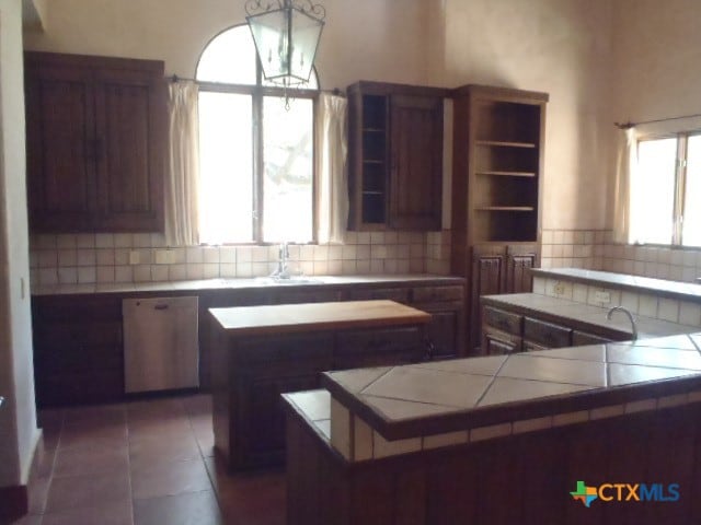 kitchen with decorative backsplash, a wealth of natural light, and tile counters