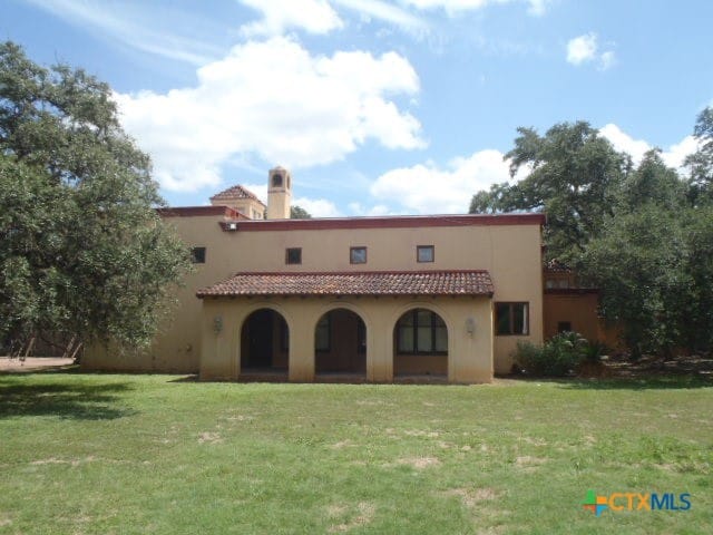 rear view of house featuring a lawn