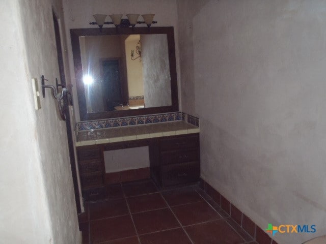 hallway featuring dark tile patterned flooring