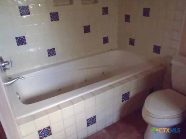 bathroom featuring tile walls and toilet