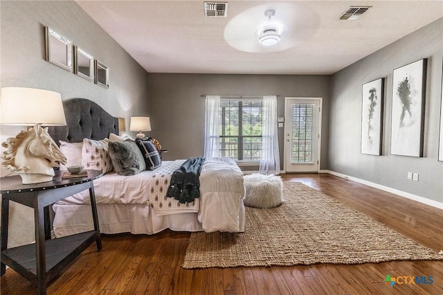 bedroom with visible vents, baseboards, and wood finished floors