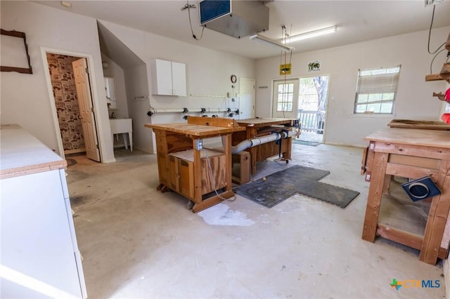 kitchen with white cabinets, unfinished concrete floors, and light countertops