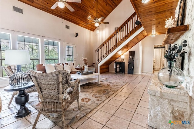 tiled living area with wooden ceiling, a wealth of natural light, visible vents, and stairway