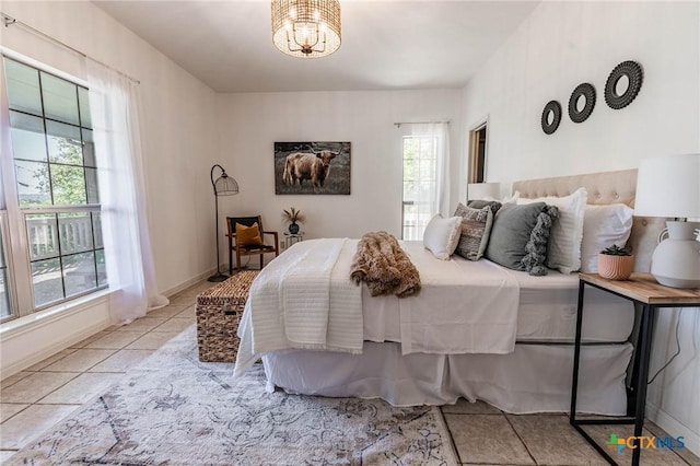 bedroom with tile patterned floors and a notable chandelier