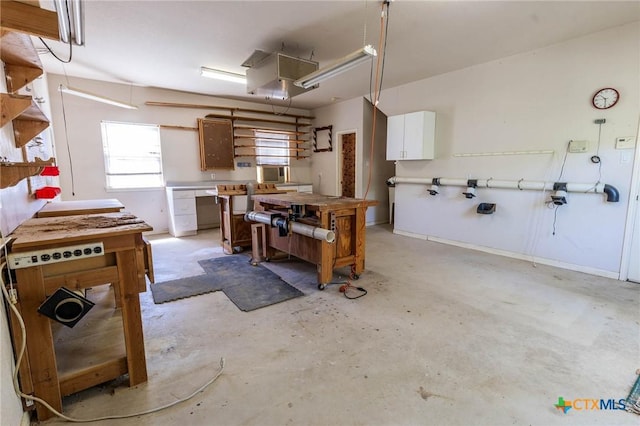 interior space featuring white cabinetry, light countertops, and unfinished concrete flooring