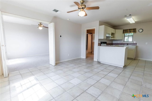 kitchen with open floor plan, stove, and a ceiling fan
