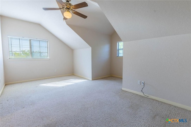 additional living space with ceiling fan, baseboards, lofted ceiling, and carpet