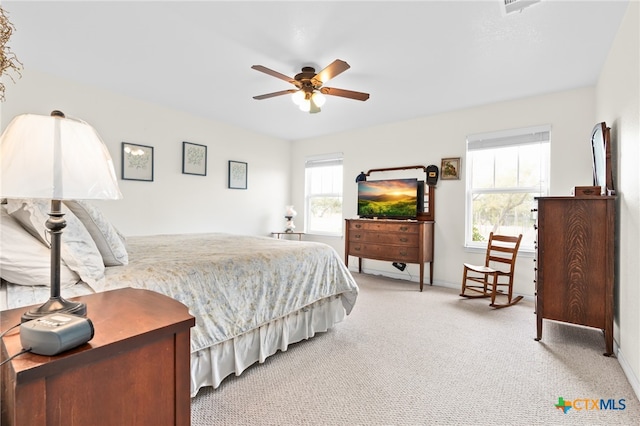 carpeted bedroom featuring ceiling fan and multiple windows