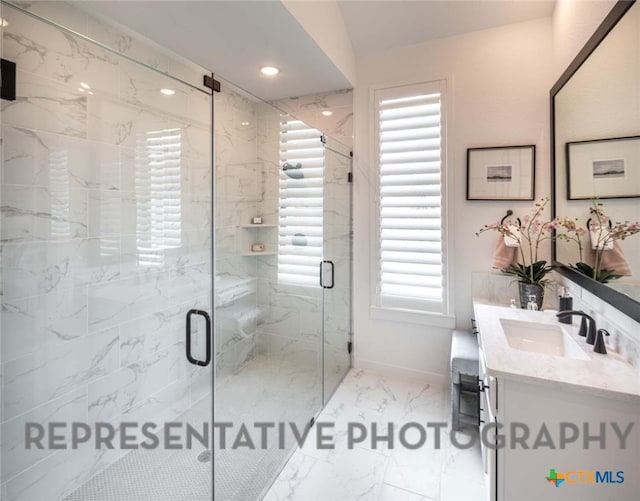 bathroom with plenty of natural light, a shower with shower door, and vanity