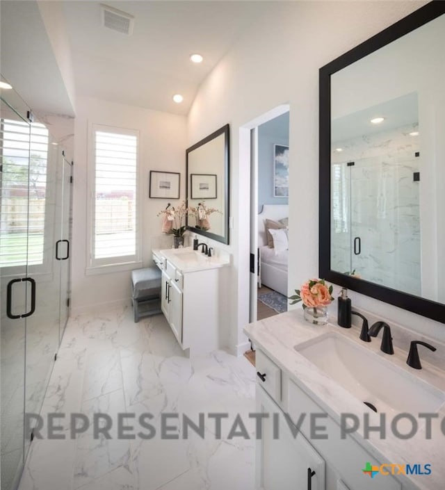 bathroom with vanity and a shower with door