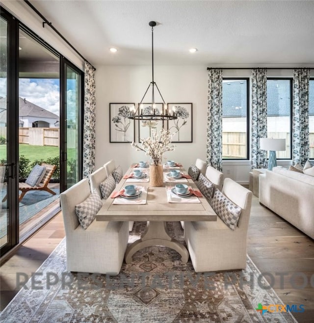 dining area featuring an inviting chandelier, hardwood / wood-style floors, and a textured ceiling