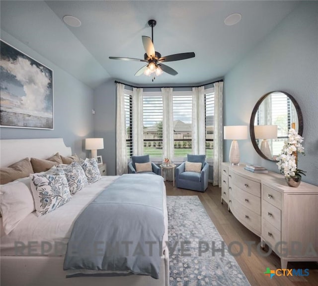 bedroom featuring ceiling fan, lofted ceiling, and light hardwood / wood-style floors