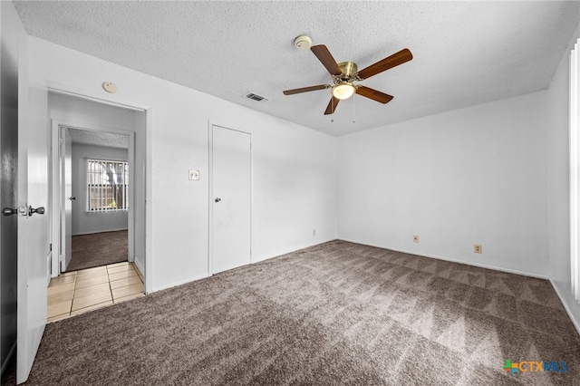 2310 Bunker Hill Dr, Temple, TX 76504 - unfurnished bedroom with carpet, a textured ceiling, tile patterned flooring, and ceiling fan