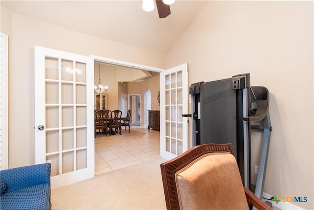 carpeted home office with ceiling fan with notable chandelier, lofted ceiling, french doors, and tile patterned floors