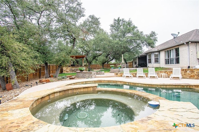 view of swimming pool with a fenced backyard and a pool with connected hot tub