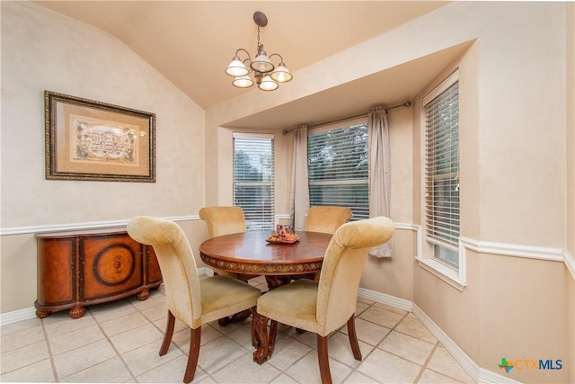 dining area featuring baseboards, a chandelier, vaulted ceiling, and light tile patterned flooring