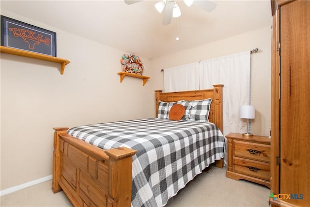 bedroom with ceiling fan, baseboards, and light colored carpet