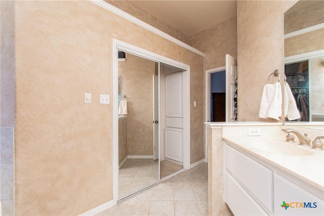 bathroom featuring tile patterned flooring, vanity, and baseboards