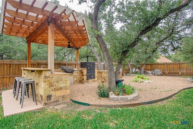 view of patio / terrace with a fenced backyard, a grill, outdoor dry bar, and area for grilling