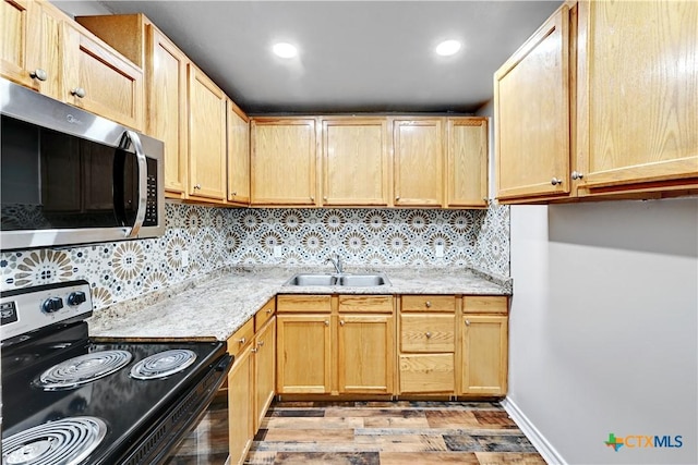 kitchen with light brown cabinets, range with electric stovetop, a sink, decorative backsplash, and stainless steel microwave