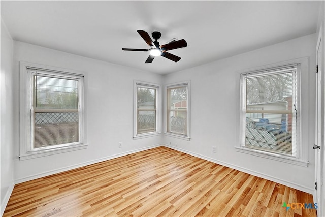 empty room featuring ceiling fan, baseboards, and wood finished floors