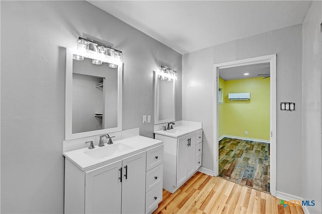 full bathroom featuring a wall mounted air conditioner, two vanities, a sink, and wood finished floors