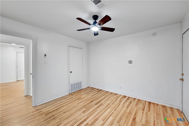 spare room featuring ceiling fan, visible vents, and light wood-style floors