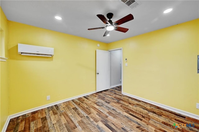 unfurnished room featuring ceiling fan, wood finished floors, visible vents, baseboards, and an AC wall unit