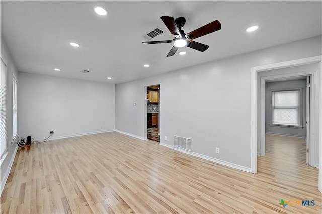 spare room with ceiling fan and light wood-type flooring