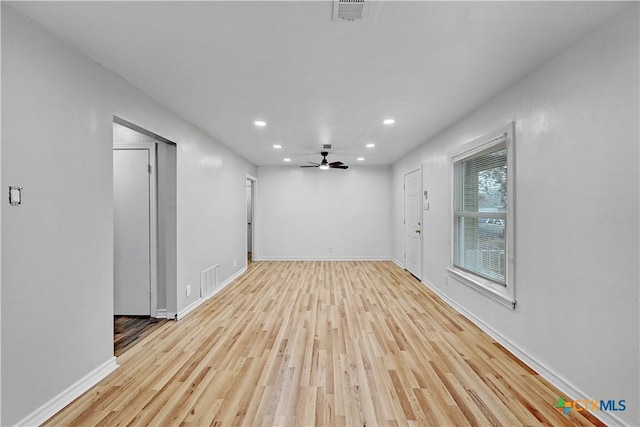 unfurnished room with baseboards, wood finished floors, visible vents, and recessed lighting