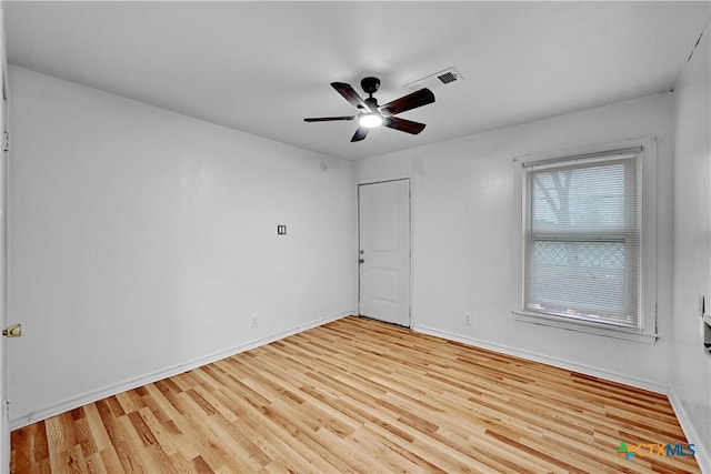 unfurnished room with light wood finished floors, visible vents, baseboards, and a ceiling fan