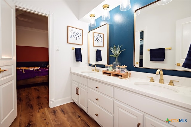 bathroom featuring ornamental molding, wood-type flooring, and vanity