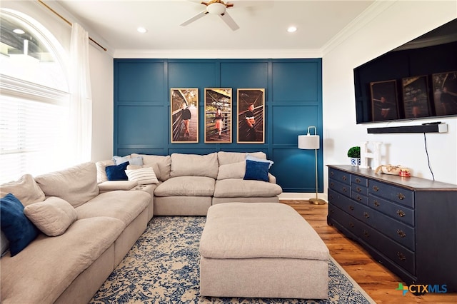 living room featuring hardwood / wood-style floors, ceiling fan, and ornamental molding