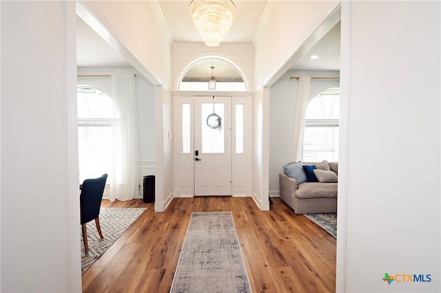 entryway with hardwood / wood-style floors, a healthy amount of sunlight, and crown molding