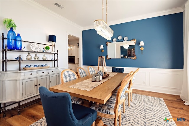 dining space with hardwood / wood-style floors and crown molding