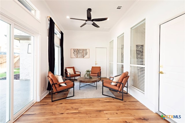 sitting room with a wealth of natural light, ceiling fan, and light wood-type flooring