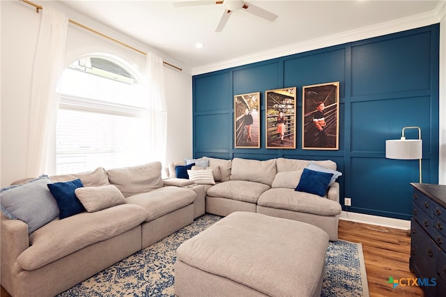 living room with hardwood / wood-style flooring, ceiling fan, and ornamental molding