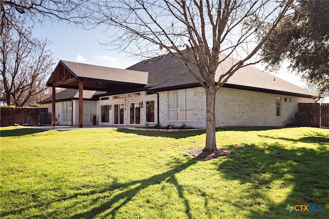 rear view of house with central AC, a yard, and a patio area