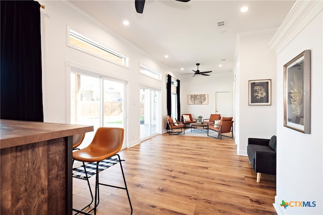 interior space featuring crown molding, ceiling fan, and light hardwood / wood-style flooring