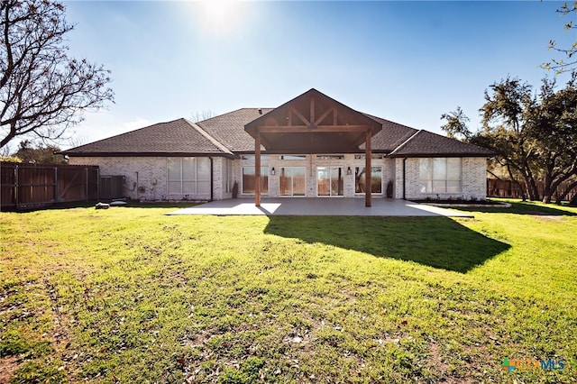 rear view of property featuring a patio and a yard