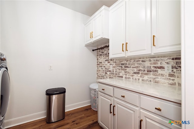 laundry room with dark wood-type flooring and cabinets