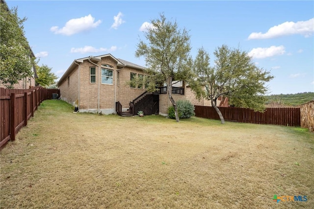8113 Cannon Ct, Lago Vista, TX 78645 - view of side of property with a fenced backyard, brick siding, and stairway