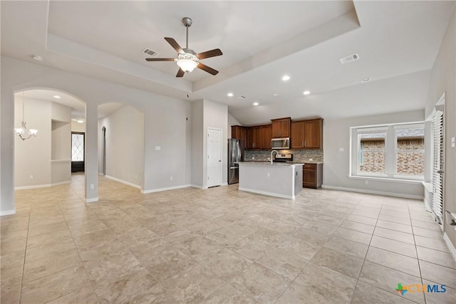 8113 Cannon Ct, Lago Vista, TX 78645 - unfurnished living room with a raised ceiling, plenty of natural light, ceiling fan, arched walkways, and recessed lighting
