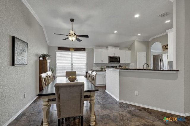 dining area featuring lofted ceiling, crown molding, and ceiling fan